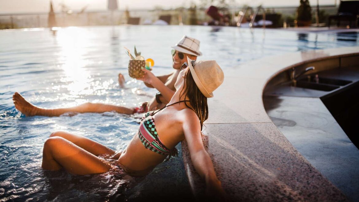 Mulher relaxando em piscina de hotel ao pôr do sol, ilustrando hospedagem de viagem